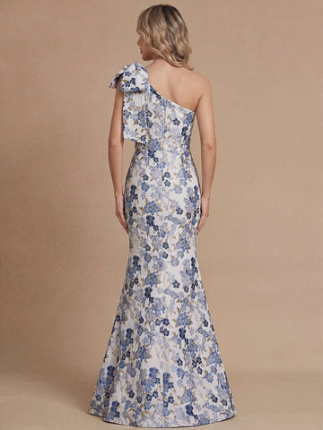 Vedress floral mermaid mother bride gown back view,one‑shoulder bow,hidden center back zipper,all‑over blue floral jacquard fabric,solid tan backdrop