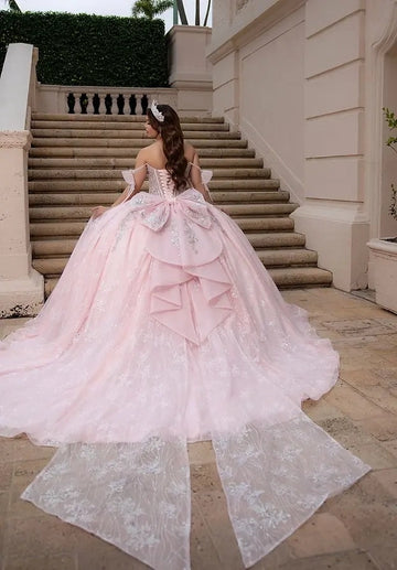 Vedress blush pink quinceañera gown lace-up corset back oversized layered ruffle big bow, glitter lace long train back view