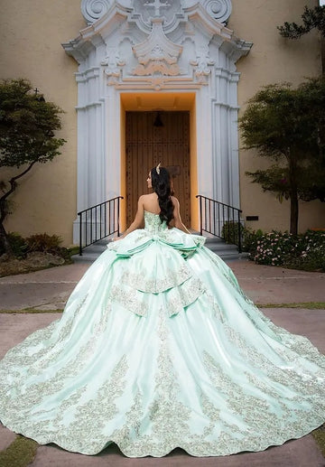 Vedress mint green quinceañera gown lace-up corset back large satin bow layered ruffle gold lace long train back view