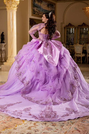 Back view of lavender Quinceañera dress with corset back, oversized satin bow, ruffled skirt and sweeping train