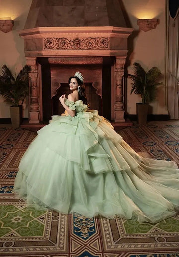 Vedress sage green quinceañera gown lace-up corset back oversized layered ruffle big bow, tiered glitter tulle long train back view