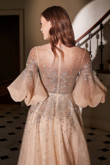 Vestido de noche formal línea A de tul con mangas abullonadas y abalorios color champán y cuello alto transparente