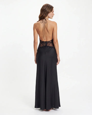 Back view of black wedding guest dress with halter ties, open back, lace waist and floor-length skirt