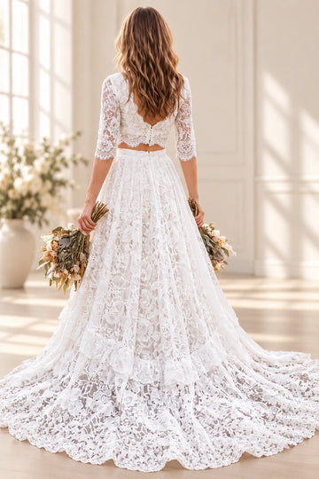 Vedress two-piece lace wedding dress with an open-back crop top, short button closure and gathered skirt with a sweeping train, back view