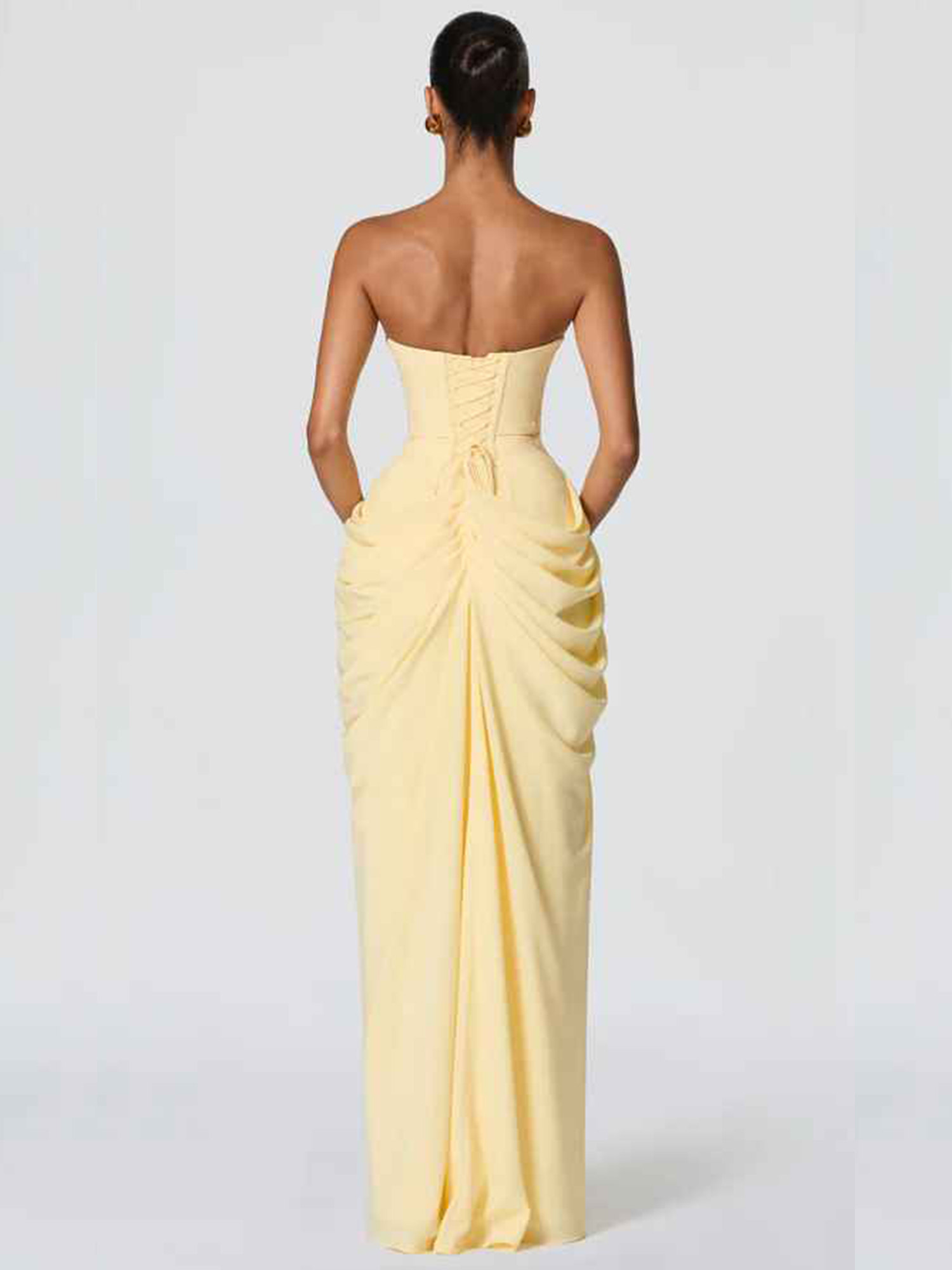 Open-back strapless formal gown with lace-up corset closure, ruched waist, sheath silhouette, and floor-length skirt