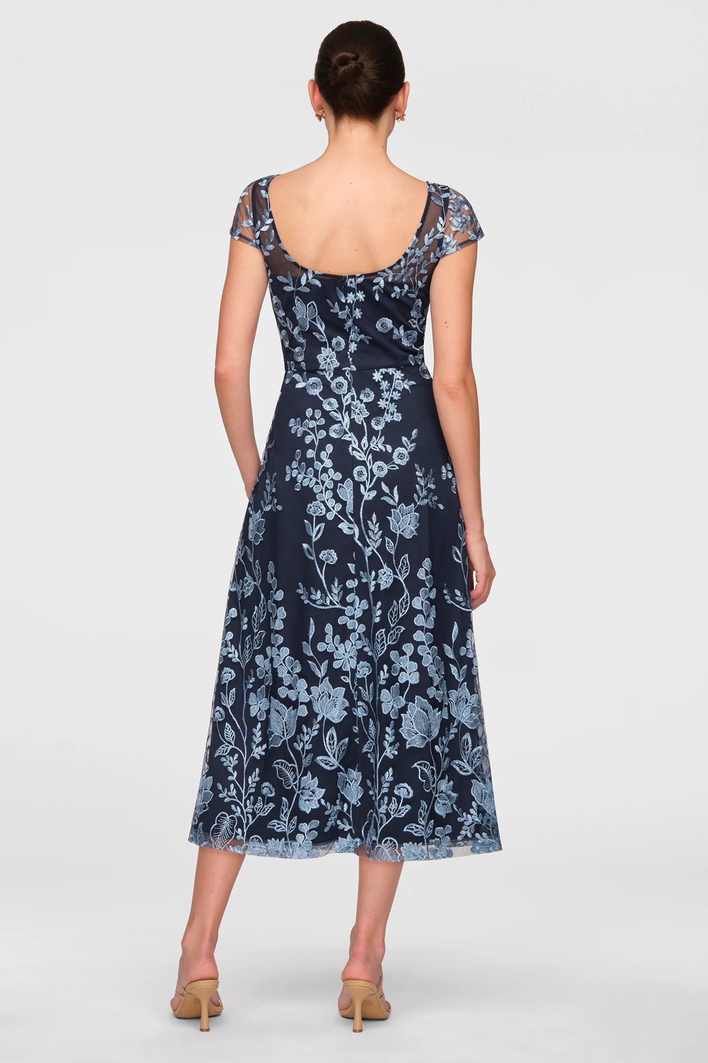 Back view of embroidered tulle A-line midi formal dress with sheer cap sleeves, scoop back, and floral overlay for special occasions