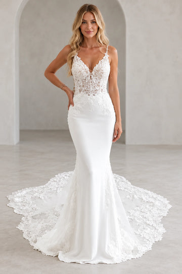 Vedress white lace mermaid wedding dress with a plunging V-neckline, spaghetti straps, illusion bodice, and scalloped lace train.