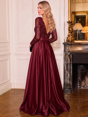 Back view of Vedress burgundy evening dress with a deep V-back, center zipper, sequin long sleeves, and flowing skirt.