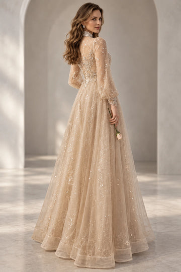 Rear three-quarter view of a Vedress champagne evening dress showing a sheer embellished back, long bishop sleeves and a flowing tulle skirt