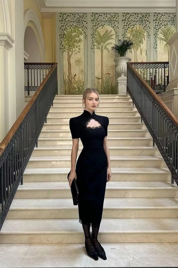 Black high neck wedding guest dress with lace cutout, structured short sleeves and fitted midi silhouette by Vedress