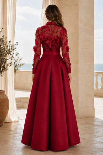 Burgundy floral lace mother of the bride gown featuring sheer embroidered back, long sleeves, fitted belted waist and flowing floor-length back skirt.