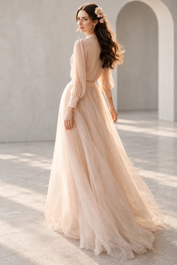 Back view of Vedress wedding dress with a covered back, gathered waist, three-quarter bishop sleeves and floor-length tulle skirt.