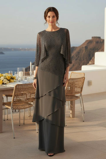 Charcoal gray mother of the bride dress with shimmering round-neck bodice, sheer cape sleeves and asymmetrical layered floor-length skirt, front view.
