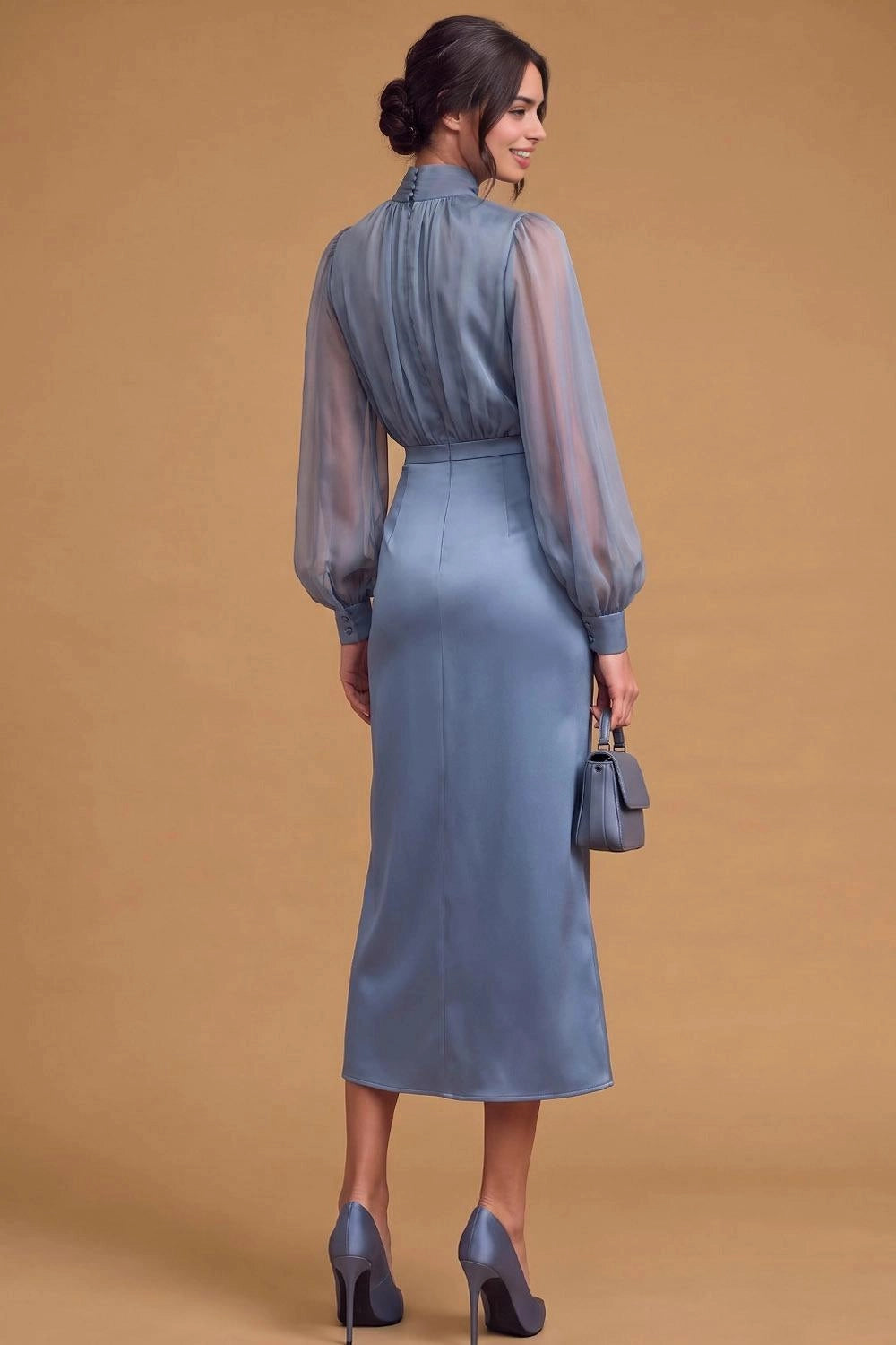 Back view of dusty blue wedding guest dress featuring button-detail high collar, gathered bodice, sheer long sleeves, and fitted midi-length skirt.