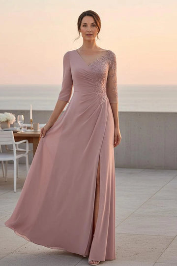 Dusty rose A-line mother of the bride dress with asymmetrical V-neckline, floral lace bodice, three-quarter sleeves, ruched waist and side slit, front view.