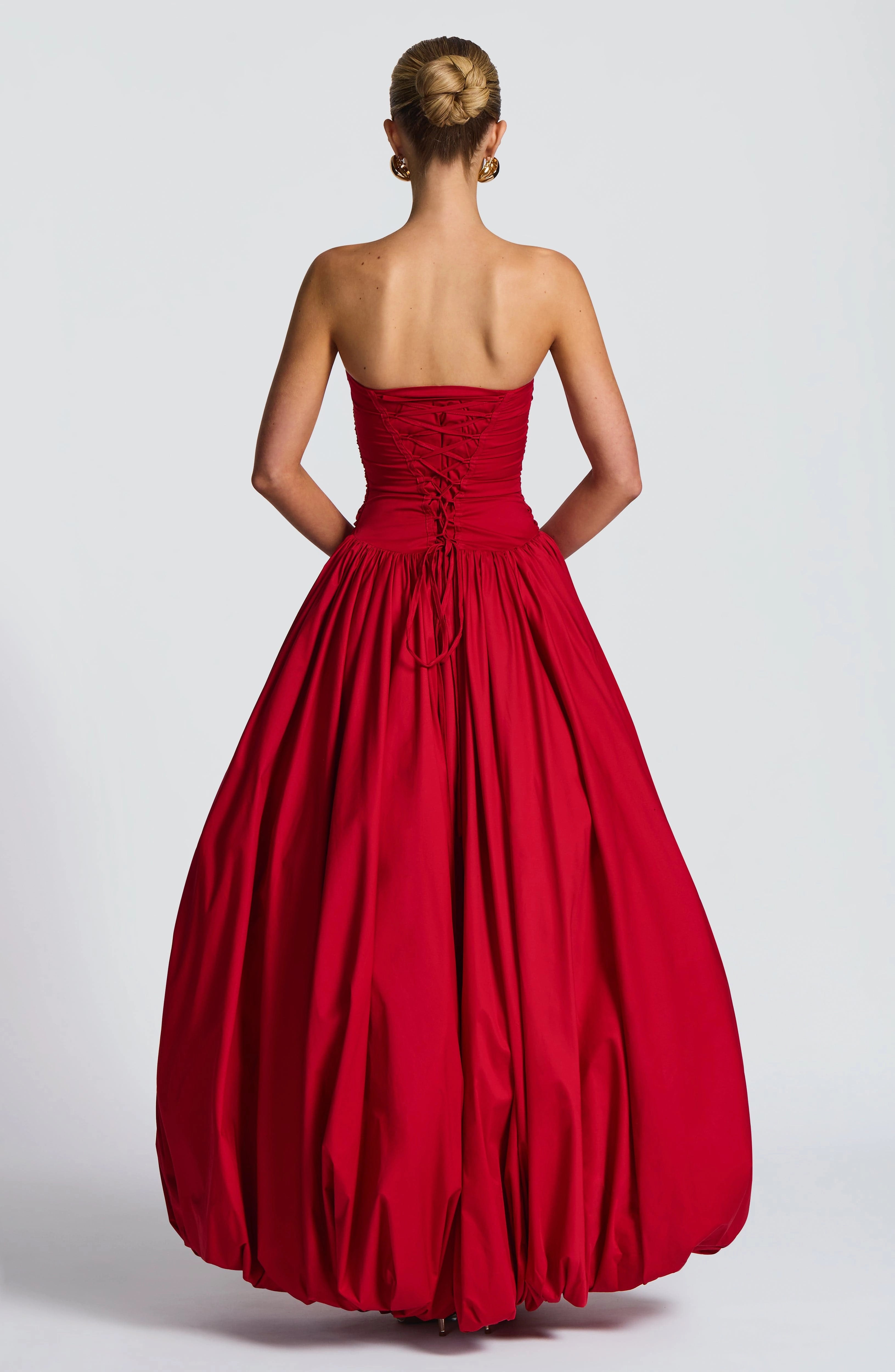 Red prom dress with crisscross spaghetti straps and adjustable lace-up corset back view