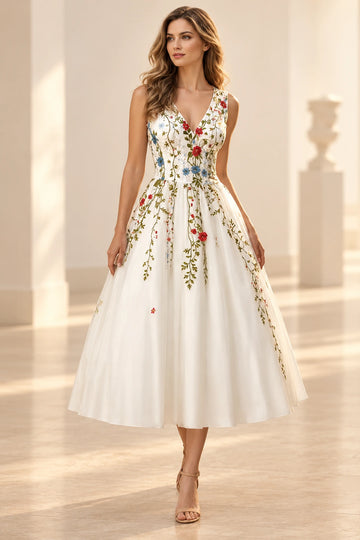 Front view of a Vedress ivory tulle wedding dress with colorful floral embroidery, a sleeveless V-neck bodice and a tea-length A-line skirt