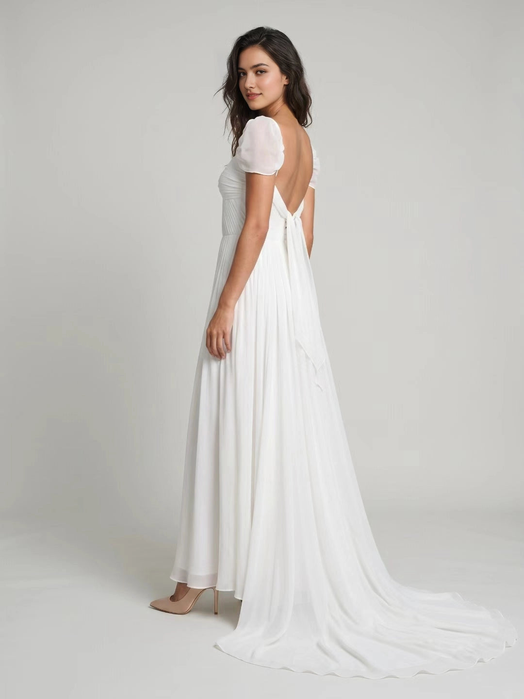 Back view of Vedress open low‑back wedding dress with fabric tie bow and chapel train