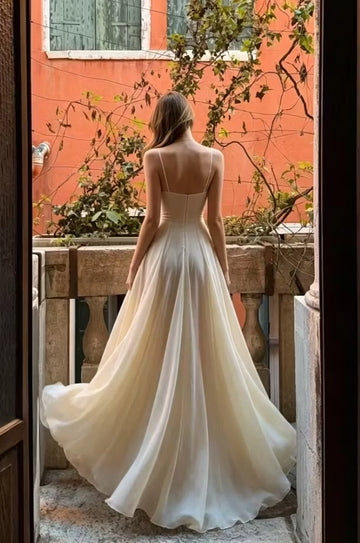 Ivory floor-length prom dress with slim straps, low back and flowing skirt