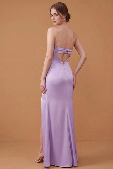 Back view of lavender satin-look bridesmaid dress featuring a bow-style band, geometric open-back cutout, center-back zipper, and long fitted skirt.