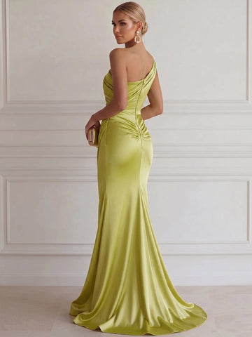 Light green one-shoulder mermaid prom gown with asymmetrical back neckline, center zipper closure, ruched hip detail and flowing floor-length hem, back view.
