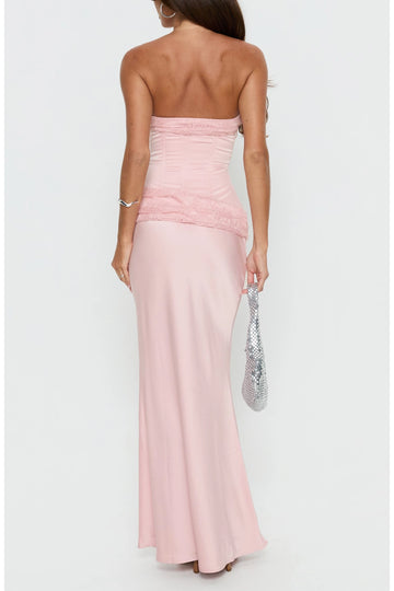 Back view of light pink strapless prom dress featuring a straight lace-trimmed back, fitted bodice, asymmetric lace hip overlay and long sheath skirt.