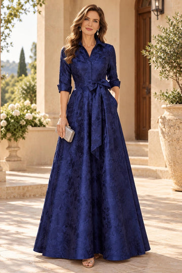 Navy blue A-line mother of the bride dress featuring floral jacquard-look pattern, collared V-neck, three-quarter sleeves, bow waist and floor-length skirt