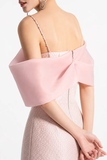 Back view of blush pink mini cocktail Dress with beaded straps, oversized off shoulder bow detail, textured fabric, and back zipper closure