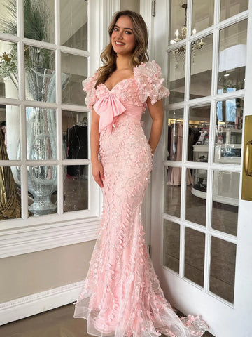 Pink floor length prom dress with bow detail, floral appliqués and fitted mermaid silhouette by