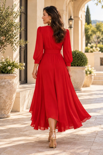 Back view of red mother of the bride dress featuring a closed back, gathered waist, bishop sleeves with fitted cuffs and flowing asymmetric high-low hem.