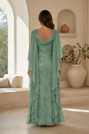 Back view of sage green beaded mother of the bride dress featuring a draped cowl back, gathered shoulders, cascading cape panels and long embellished skirt.
