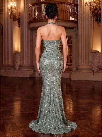 Back view of sage green sequin mermaid prom dress with a halter neck strap, open upper back, center zipper and sparkling sweep train.