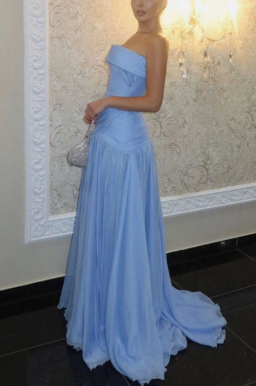 Side and partial back view of sky blue strapless prom dress with a ruched dropped waist, flowing pleated skirt and trailing hem.