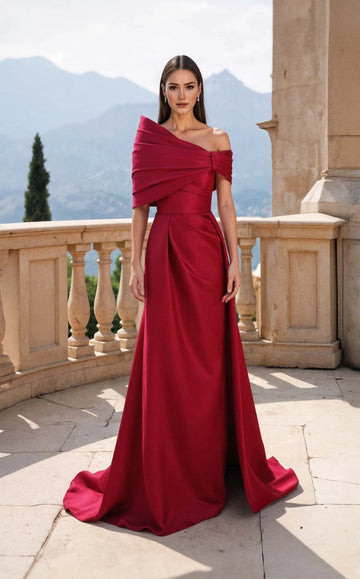Front view of a burgundy floor-length wedding guest dress with an asymmetric draped neckline and cape-like shoulder detail