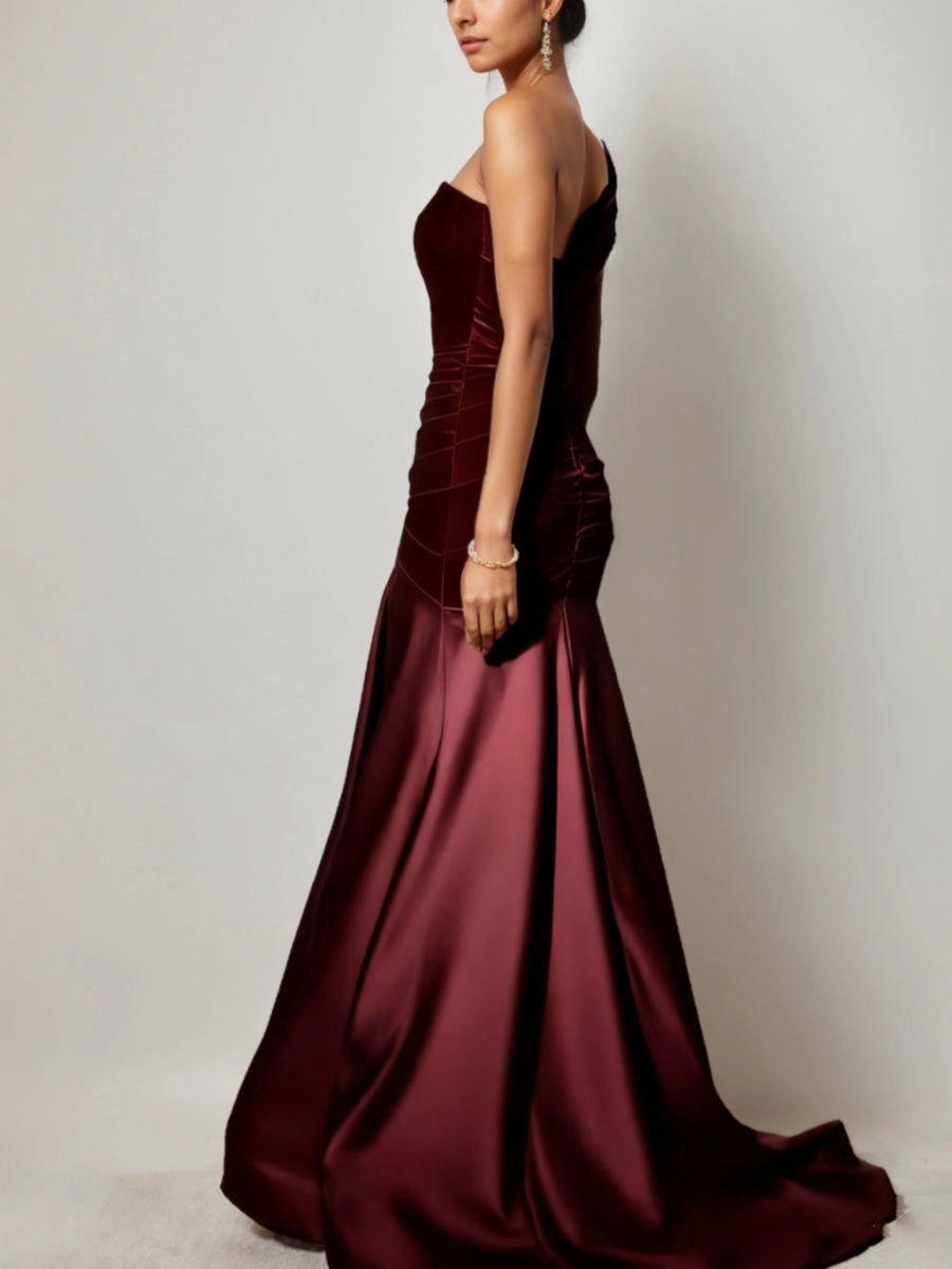 Vedress burgundy mermaid mother bride gown side‑back view,one shoulder silhouette,ruched velvet waist,wide satin skirt with sweep train,solid light‑grey backdrop
