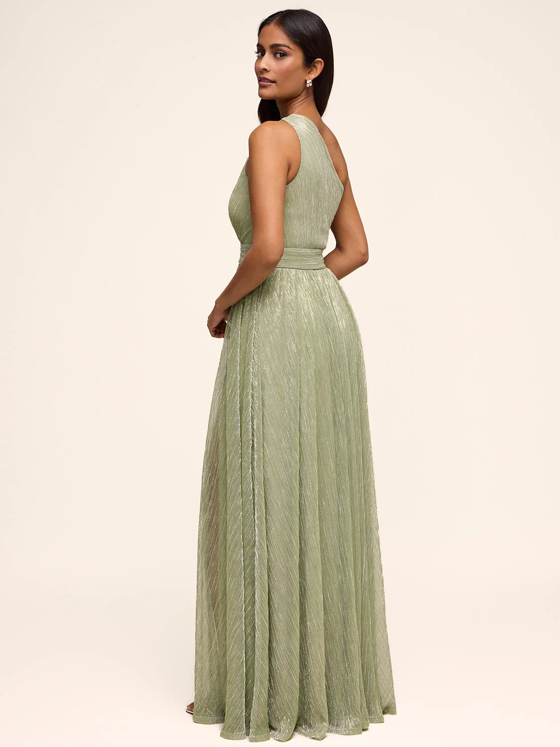 Back view of one-shoulder A-line formal gown with pleated shimmer fabric, fitted waist, and flowing floor-length skirt for weddings and evening events
