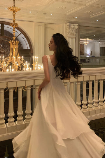 Back view of ivory wedding dress with scoop back and layered asymmetric A-line skirt by Vedress