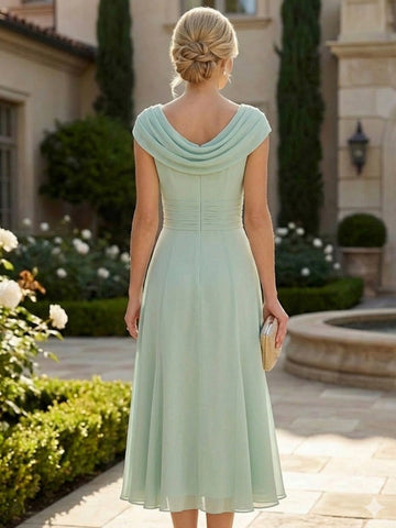 Model wearing vedress sage chiffon mother of bride dress cowl back midi formal outfit rear view