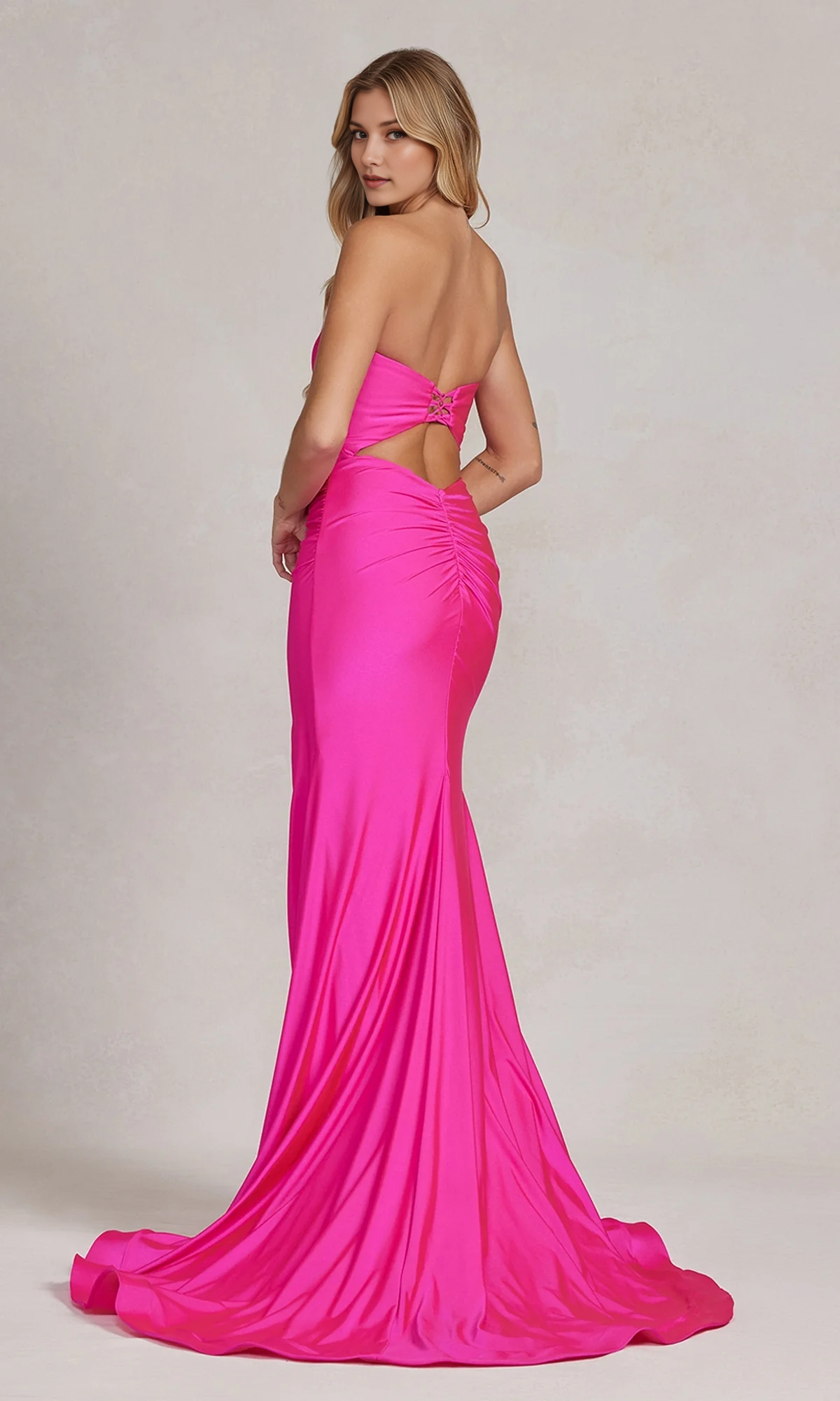 Open-back hot pink mermaid formal gown with lace-up detail, ruched back, side cutout, and floor-length train