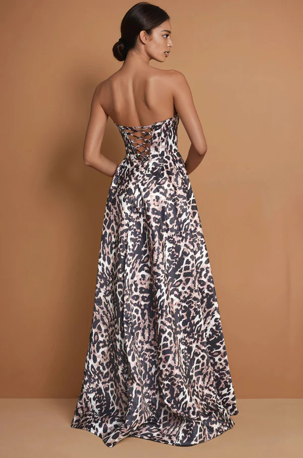 Back view of leopard print strapless formal gown with lace-up back, adjustable corset detail, and flowing A-line floor length skirt by VEDRESS