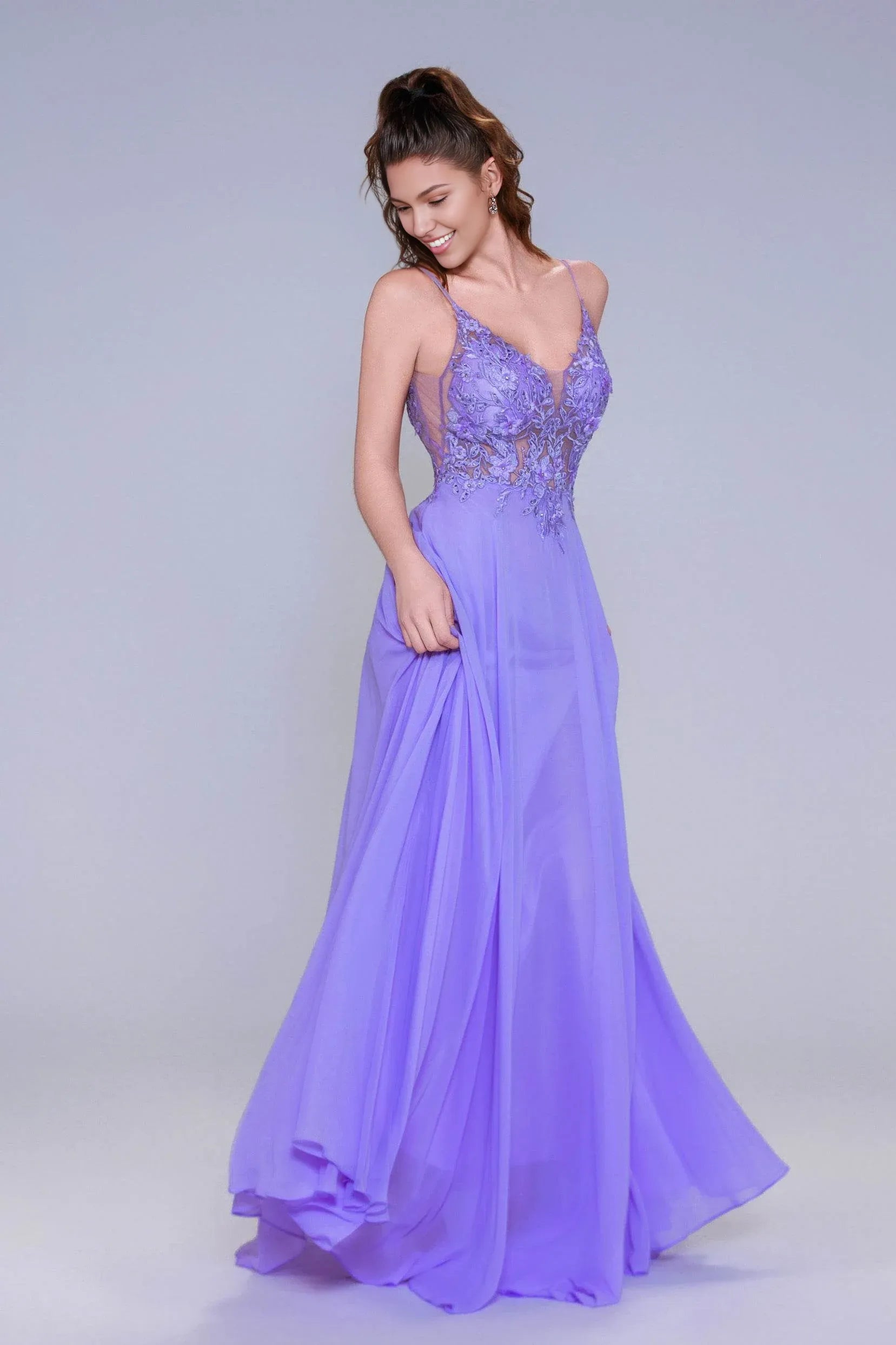 A-line evening gown with V-neckline, spaghetti straps, illusion appliqué bodice, and flowing chiffon skirt