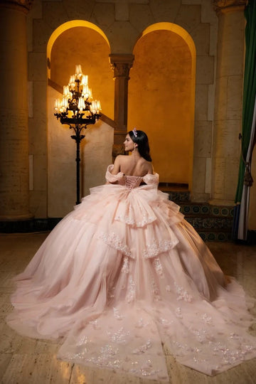 Vedress blush pink tulle quinceanera gown off shoulder puff sleeves lace-up corset back layered big bow full skirt with long train 3D flower appliques back view