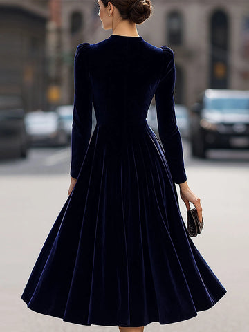 Back view of Vedress navy velvet mother of the bride dress showing a clean high back, long sleeves and flowing A-line midi skirt.