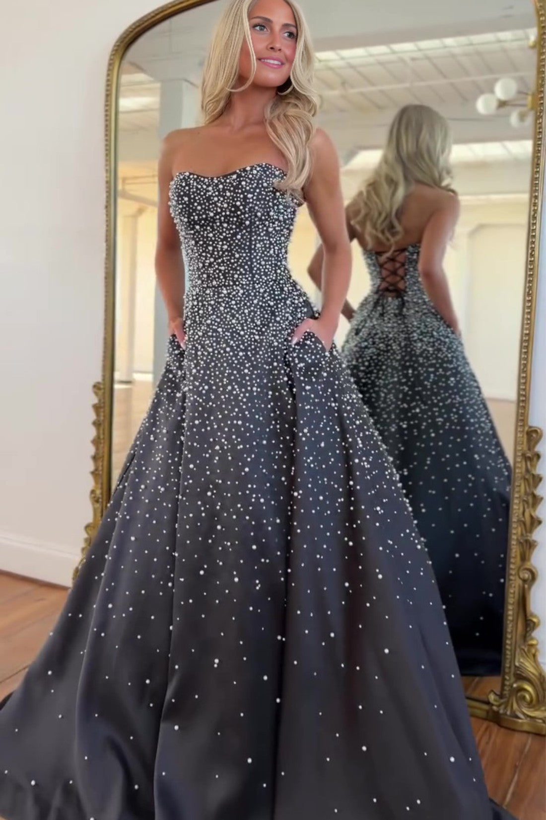 Vestido largo de satén con escote corazón sin tirantes, pedrería y bolsillos laterales, ideal para fiestas de graduación y como invitada de boda