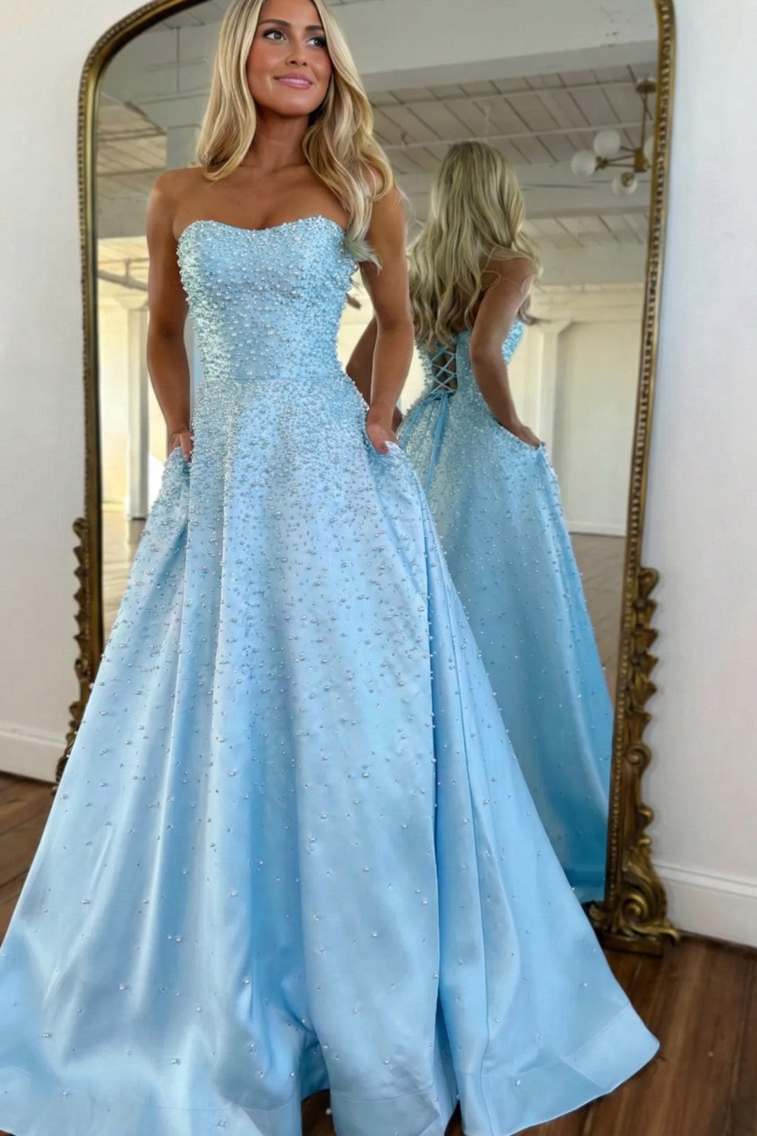 Vestido largo de satén con escote corazón sin tirantes, pedrería y bolsillos laterales, ideal para fiestas de graduación y como invitada de boda