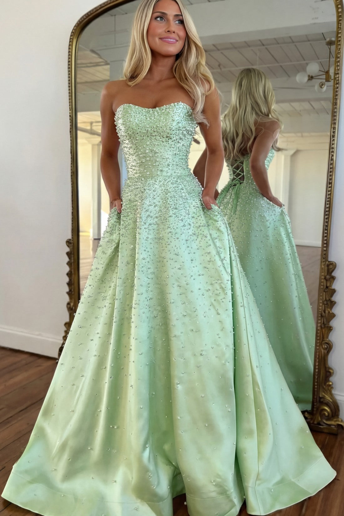 Vestido largo de satén con escote corazón sin tirantes, pedrería y bolsillos laterales, ideal para fiestas de graduación y como invitada de boda