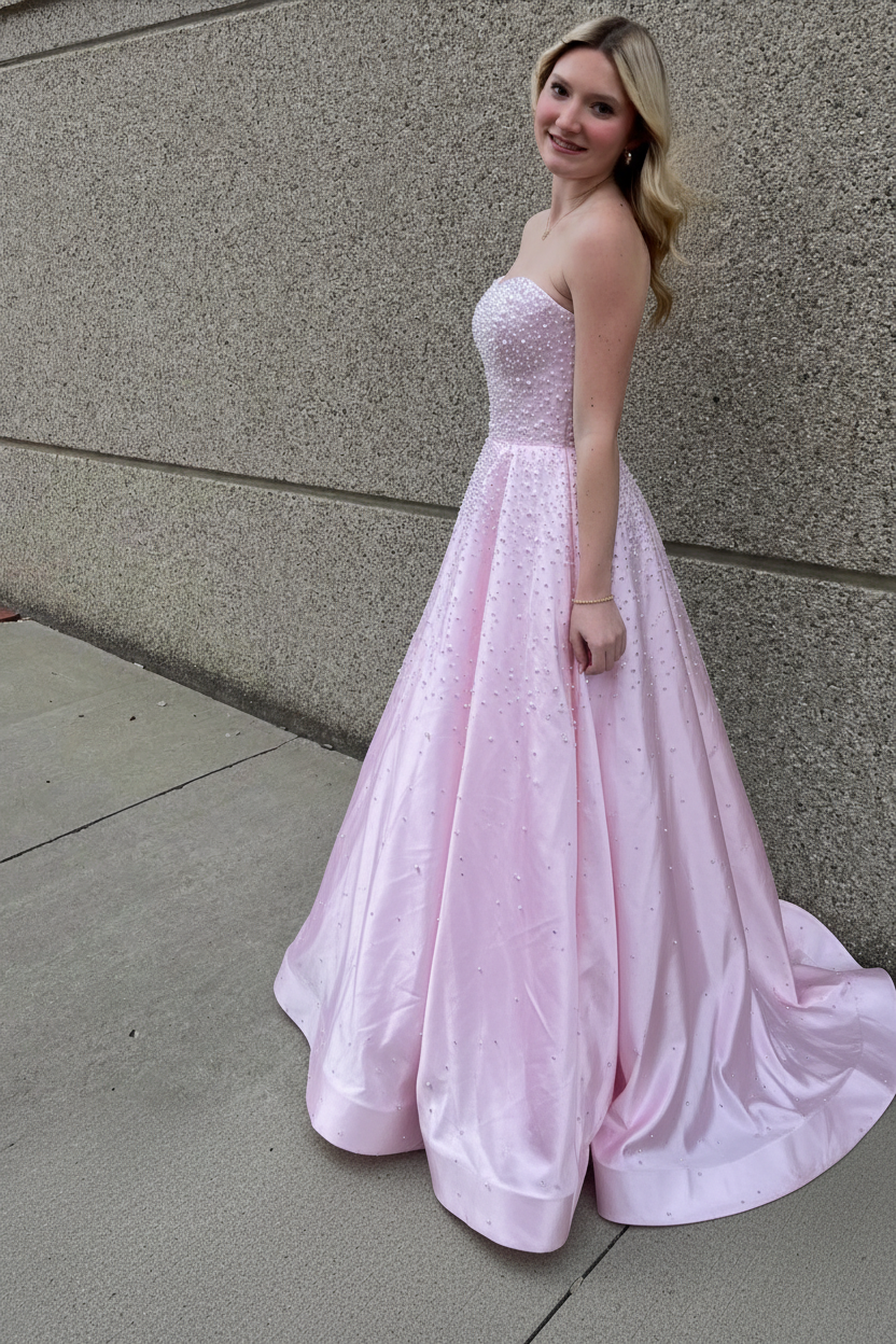 Vestido largo de satén con escote corazón sin tirantes, pedrería y bolsillos laterales, ideal para fiestas de graduación y como invitada de boda