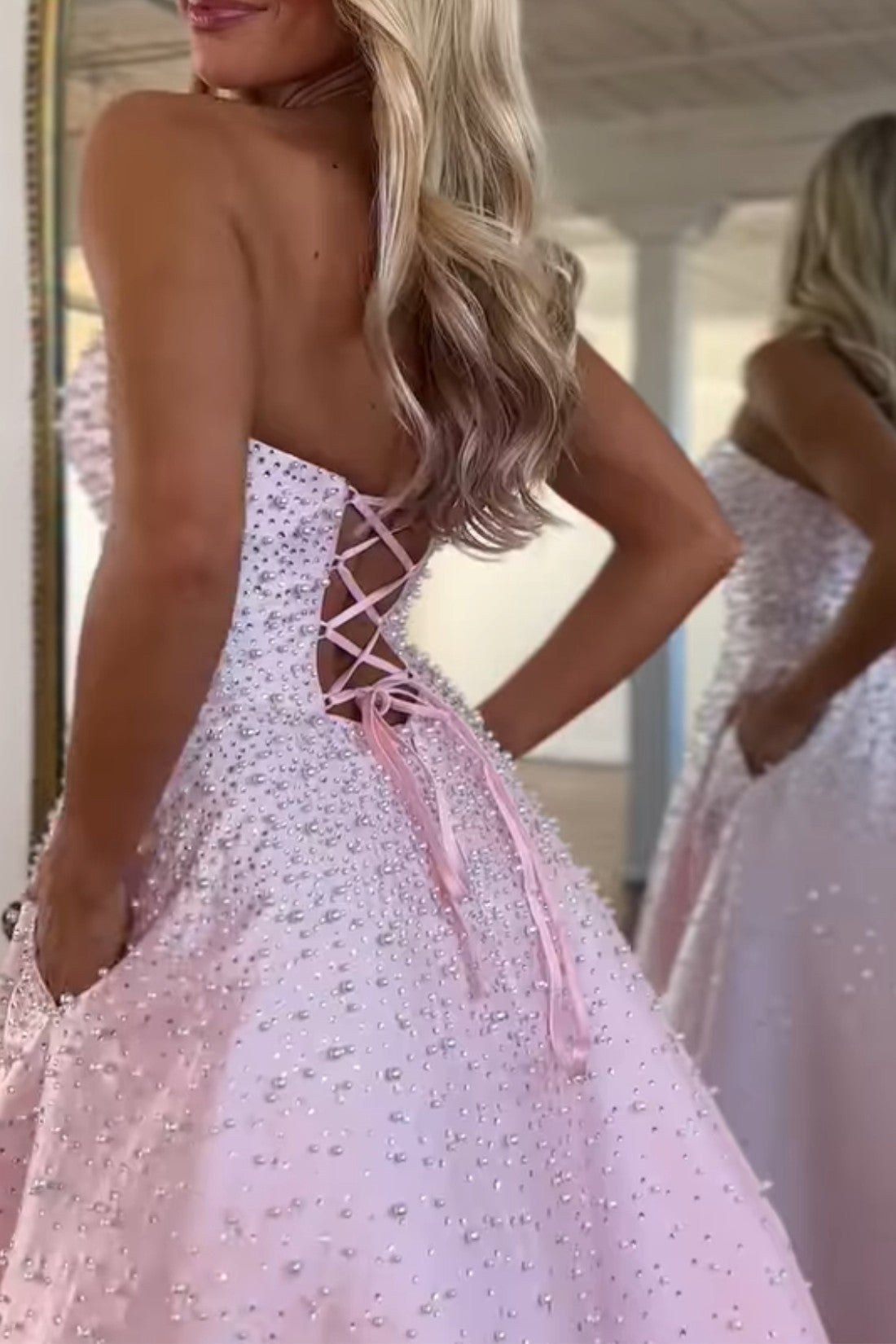 Vestido largo de satén con escote corazón sin tirantes, pedrería y bolsillos laterales, ideal para fiestas de graduación y como invitada de boda