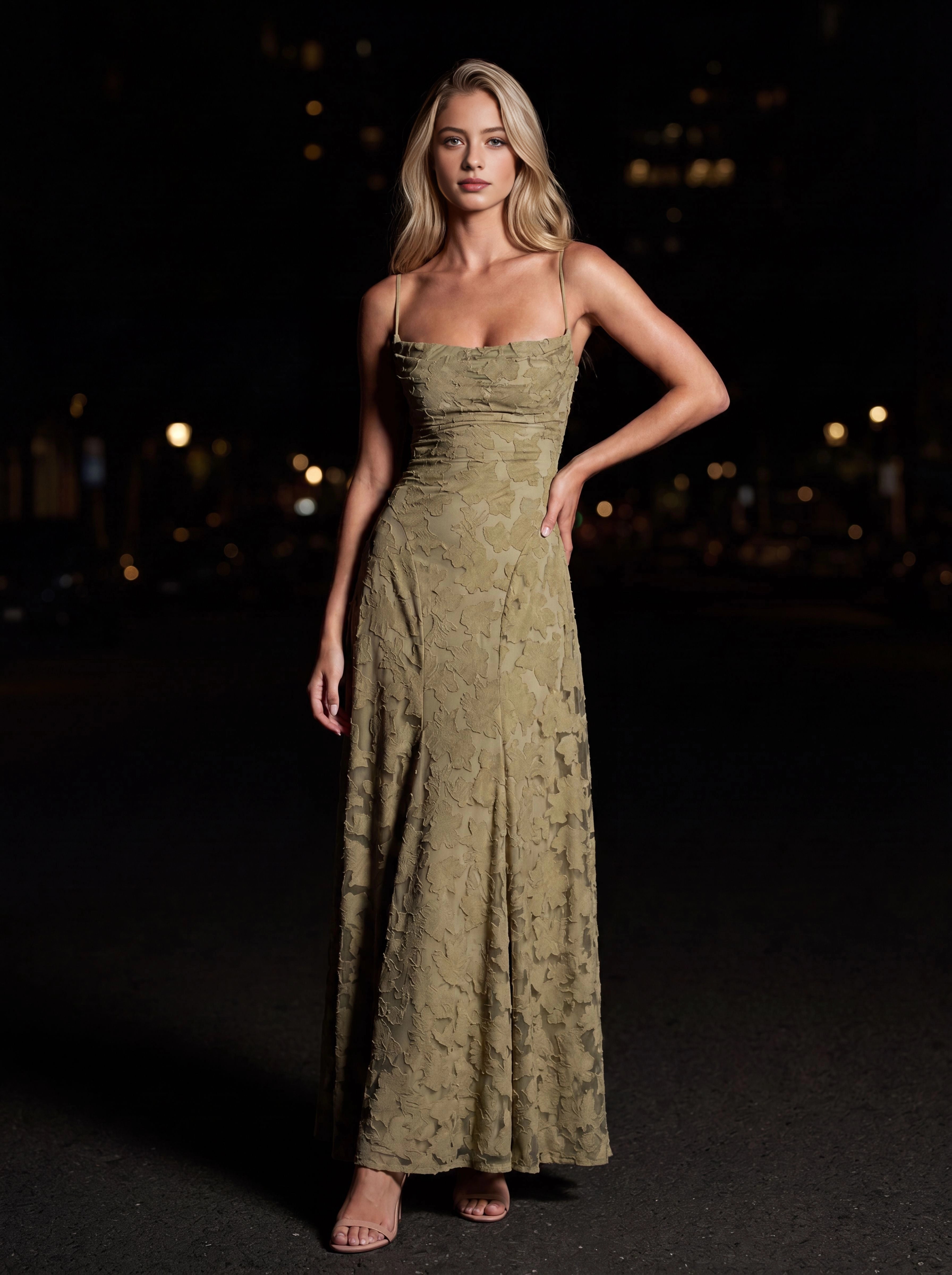 Vedress olive green bridesmaid dress,front view thin spaghetti straps,straight square neckline,3D floral textured fabric,flowy A‑line floor‑length skirt,night city background