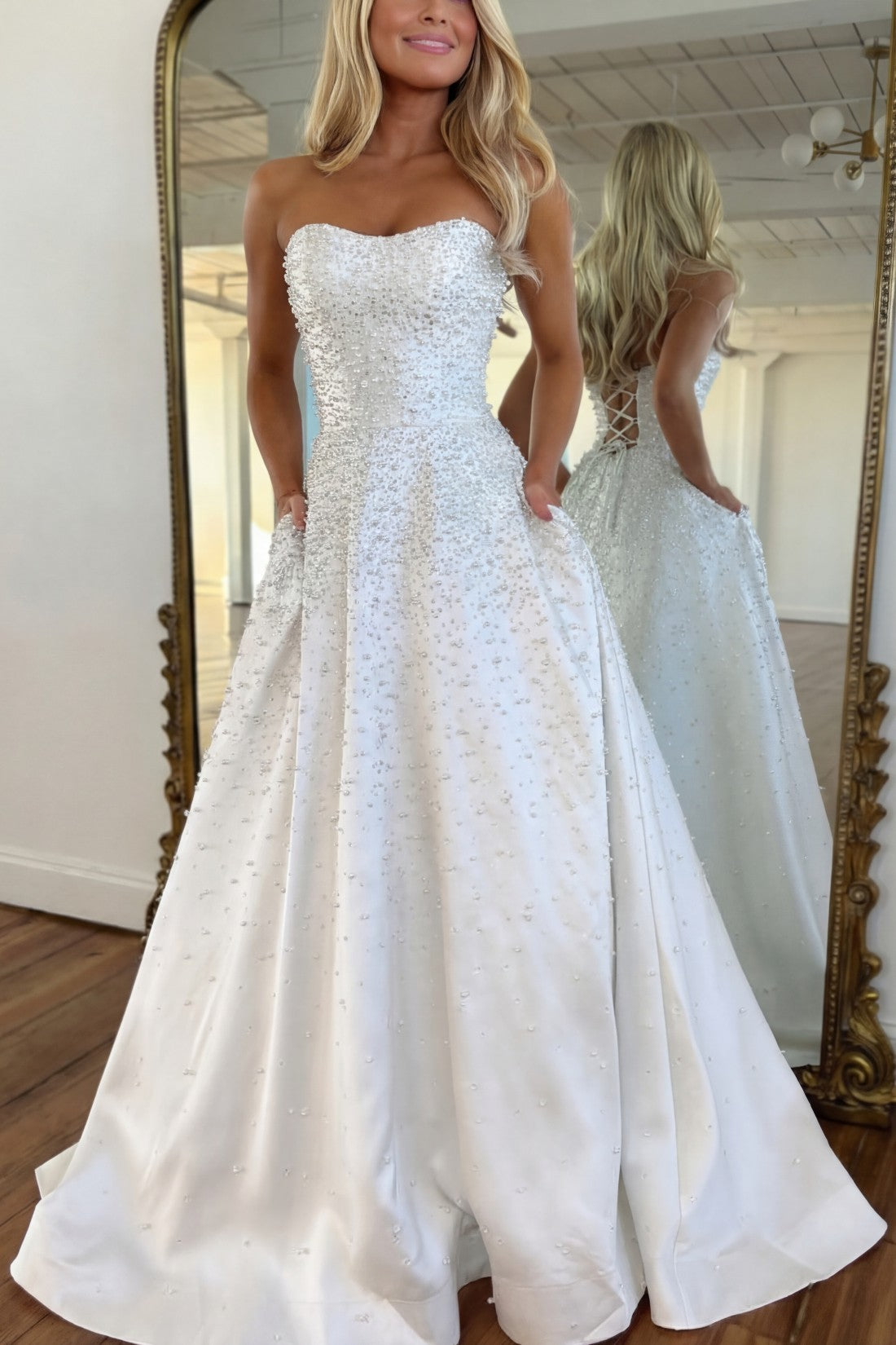 Vestido largo de satén con escote corazón sin tirantes, pedrería y bolsillos laterales, ideal para fiestas de graduación y como invitada de boda
